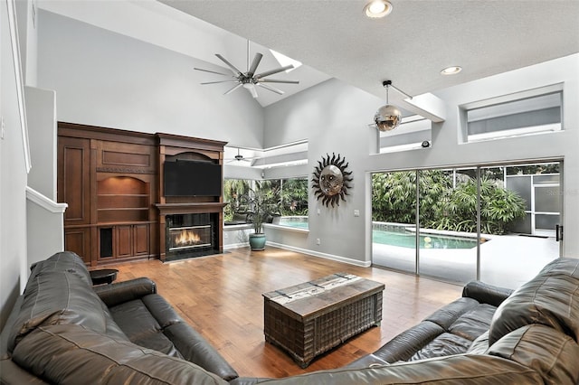 2890 Wild Ginger Ct, Winter Park, FL 32792 - living area featuring a ceiling fan, high vaulted ceiling, a glass covered fireplace, light wood-type flooring, and recessed lighting