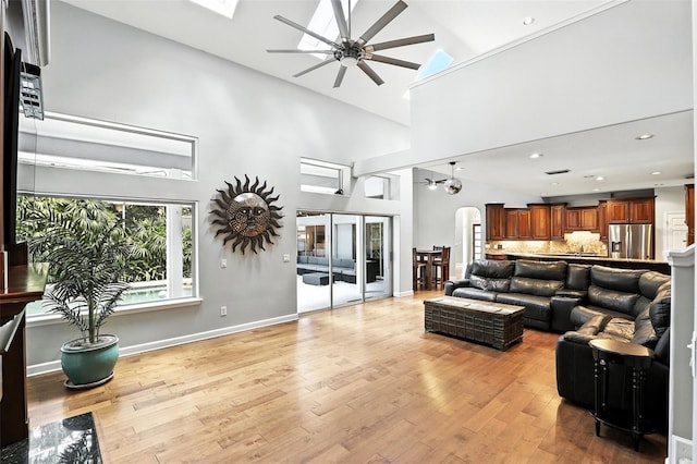 2890 Wild Ginger Ct, Winter Park, FL 32792 - living room with a ceiling fan, light wood-style flooring, a towering ceiling, arched walkways, and recessed lighting