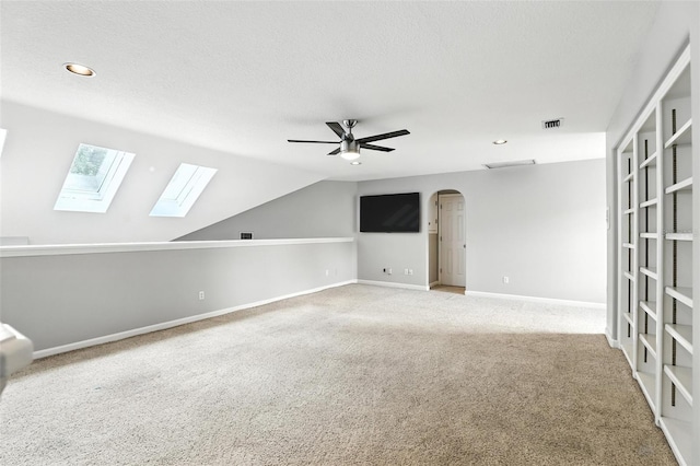 2890 Wild Ginger Ct, Winter Park, FL 32792 - spare room with a ceiling fan, carpet floors, a skylight, recessed lighting, and arched walkways