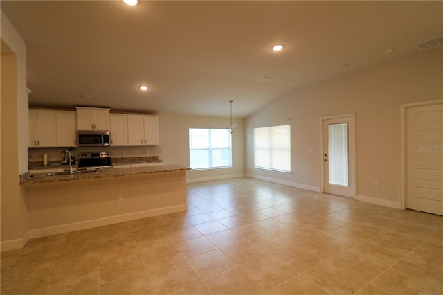 1105 Citrus Landings Blvd, Davenport, FL 33837 - kitchen featuring stainless steel appliances, vaulted ceiling, white cabinetry, recessed lighting, and a peninsula