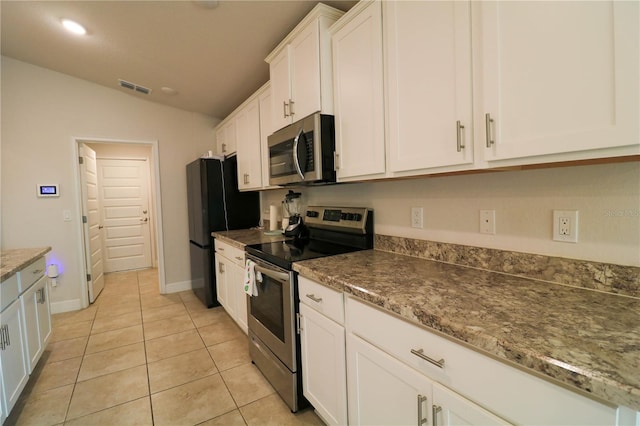 1105 Citrus Landings Blvd, Davenport, FL 33837 - kitchen featuring stainless steel appliances, vaulted ceiling, white cabinetry, and light tile patterned flooring