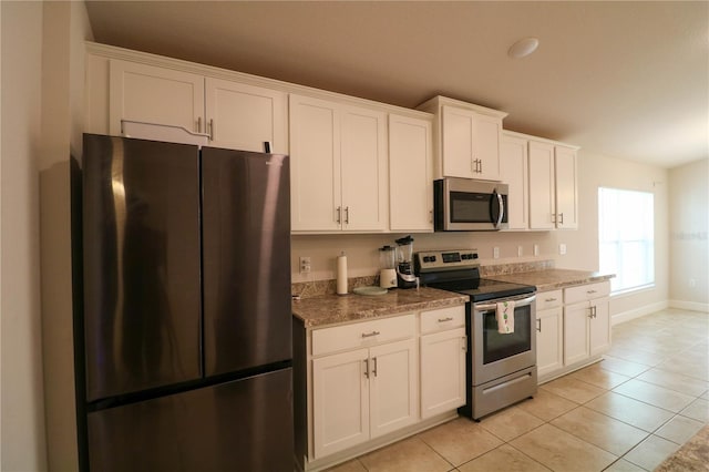 1105 Citrus Landings Blvd, Davenport, FL 33837 - kitchen featuring stainless steel appliances, light tile patterned floors, white cabinetry, and light stone countertops