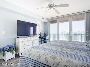 2055 S Atlantic Ave Unit 505, Daytona Beach, FL 32118 - bedroom featuring access to exterior, wood finished floors, and a ceiling fan