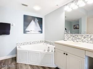 2055 S Atlantic Ave Unit 505, Daytona Beach, FL 32118 - full bathroom with wood finished floors, vanity, and a garden tub