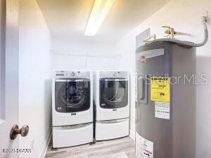 2055 S Atlantic Ave Unit 505, Daytona Beach, FL 32118 - laundry area with separate washer and dryer, light wood-style floors, and water heater