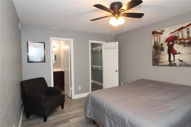 1019 S Hiawassee Rd Unit 3811, Orlando, FL 32835 - bedroom with wood finished floors, connected bathroom, a walk in closet, a ceiling fan, and a closet