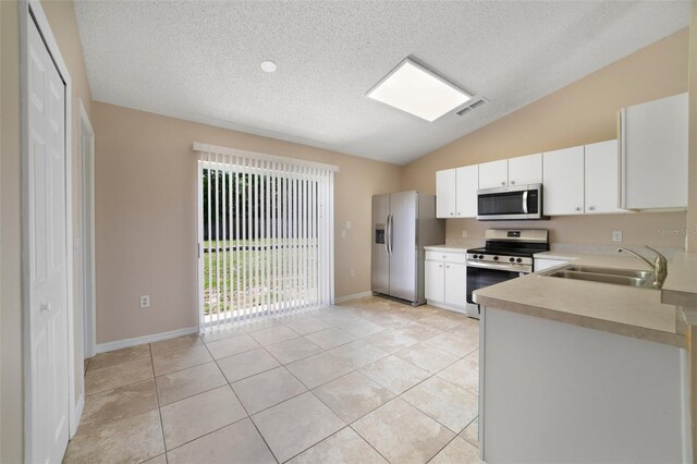 3313 Buckland St, Deltona, FL 32738 - kitchen with stainless steel appliances, light countertops, a textured ceiling, vaulted ceiling, and light tile patterned flooring