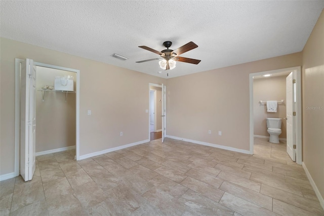 3313 Buckland St, Deltona, FL 32738 - unfurnished bedroom with a walk in closet, a closet, a textured ceiling, connected bathroom, and ceiling fan