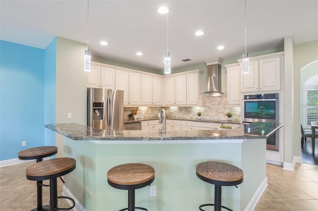 3531 Oriskany Dr, Orlando, FL 32820 - kitchen featuring stainless steel appliances, wall chimney range hood, decorative backsplash, a breakfast bar area, and dark stone counters