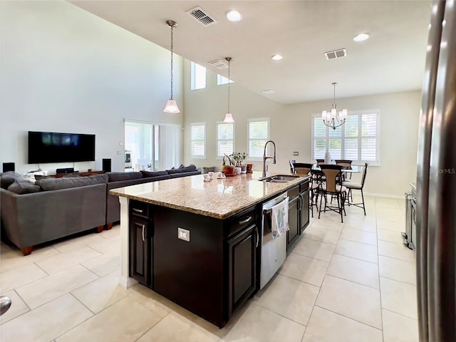 14654 Yellow Butterfly Rd, Windermere, FL 34786 - kitchen with stainless steel dishwasher, light stone countertops, recessed lighting, decorative light fixtures, and an island with sink
