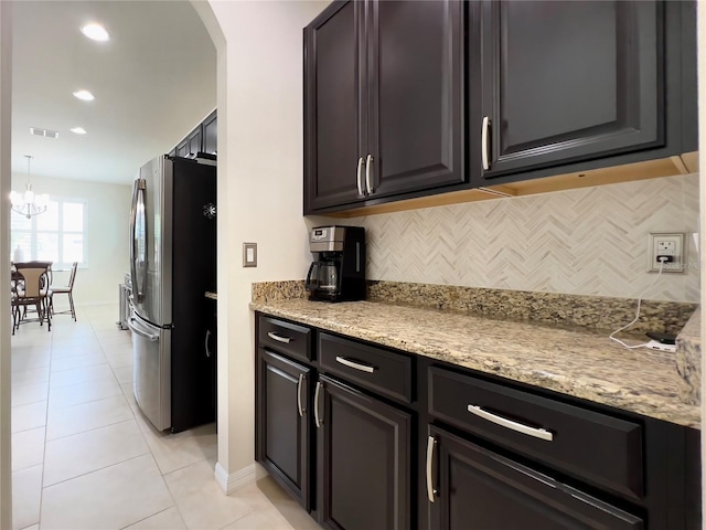 14654 Yellow Butterfly Rd, Windermere, FL 34786 - kitchen featuring freestanding refrigerator, decorative backsplash, arched walkways, light tile patterned floors, and a chandelier