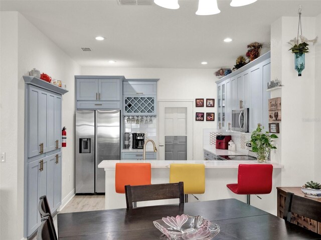 12347 NE 52nd Loop, Oxford, FL 34484 - kitchen featuring appliances with stainless steel finishes, a peninsula, a breakfast bar area, backsplash, and recessed lighting
