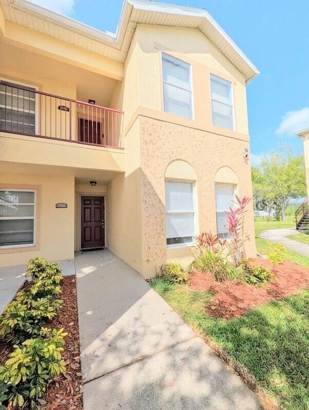 2816 Club Cortile Cir Unit A, Kissimmee, FL 34746 - view of front of property featuring a balcony and stucco siding