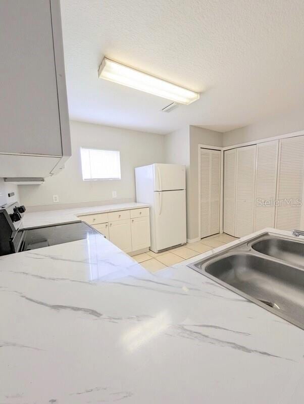 2816 Club Cortile Cir Unit A, Kissimmee, FL 34746 - kitchen featuring white appliances and light stone counters