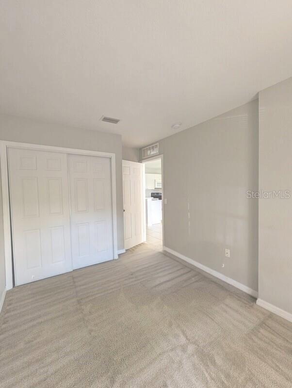 2816 Club Cortile Cir Unit A, Kissimmee, FL 34746 - unfurnished bedroom with carpet and a closet