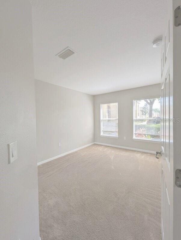 2816 Club Cortile Cir Unit A, Kissimmee, FL 34746 - empty room featuring light colored carpet