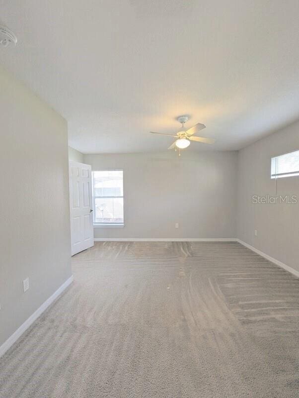 2816 Club Cortile Cir Unit A, Kissimmee, FL 34746 - spare room featuring plenty of natural light, a smoke detector, and carpet floors