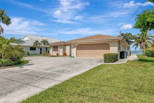 1701 Bayshore Dr, Hutchinson Island, FL 34949 - ranch-style home with driveway, a garage, a front yard, and stucco siding