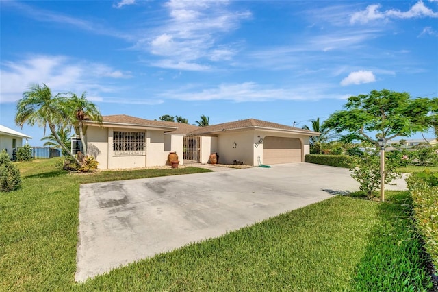 1701 Bayshore Dr, Hutchinson Island, FL 34949 - ranch-style home featuring a garage, a front yard, concrete driveway, and stucco siding