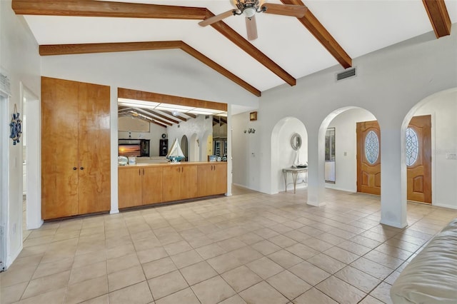 1701 Bayshore Dr, Hutchinson Island, FL 34949 - unfurnished living room featuring a ceiling fan, arched walkways, beamed ceiling, light tile patterned floors, and high vaulted ceiling