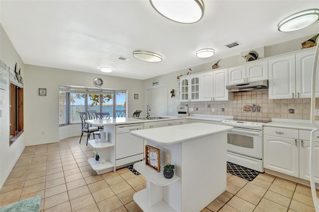 1701 Bayshore Dr, Hutchinson Island, FL 34949 - kitchen with white appliances, under cabinet range hood, open shelves, a peninsula, and a kitchen island