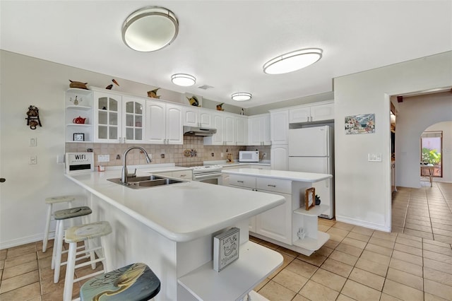 1701 Bayshore Dr, Hutchinson Island, FL 34949 - kitchen with under cabinet range hood, open shelves, white appliances, a peninsula, and light tile patterned floors