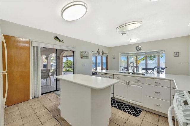1701 Bayshore Dr, Hutchinson Island, FL 34949 - kitchen with stove, a kitchen island, light tile patterned flooring, and light countertops
