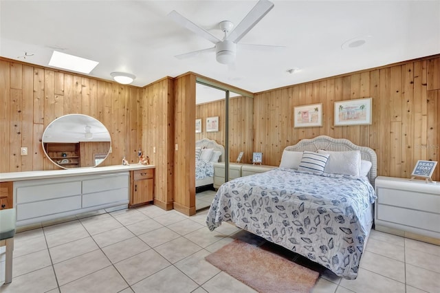 1701 Bayshore Dr, Hutchinson Island, FL 34949 - bedroom with wooden walls, light tile patterned flooring, a skylight, a closet, and ceiling fan