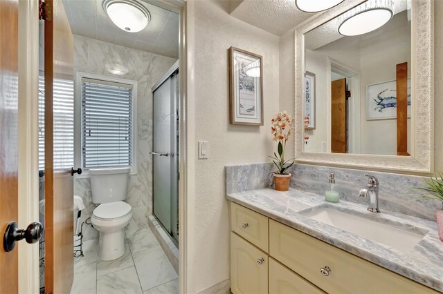 1701 Bayshore Dr, Hutchinson Island, FL 34949 - bathroom featuring marble look tiles, vanity, a stall shower, and a textured wall