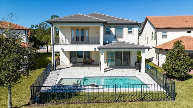 10427 Royal Cypress Way, Orlando, FL 32836 - rear view of house with a balcony, a fenced backyard, stucco siding, and a patio