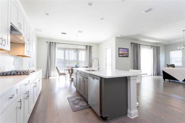 10427 Royal Cypress Way, Orlando, FL 32836 - kitchen featuring stainless steel appliances, under cabinet range hood, tasteful backsplash, light countertops, and wood finished floors