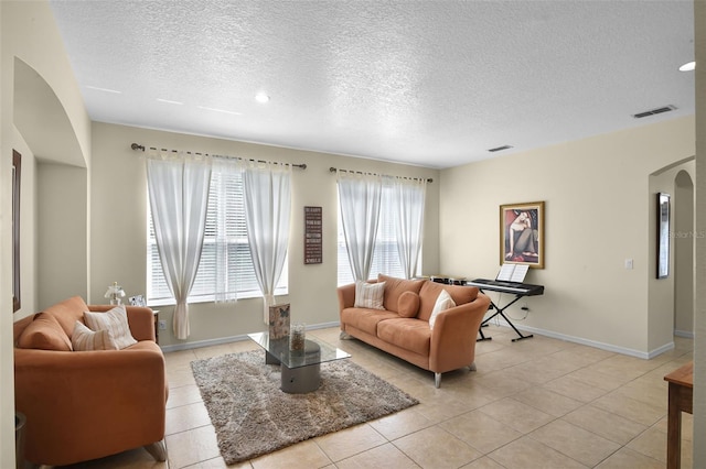 14213 Southern Red Maple Dr, Orlando, FL 32828 - living area featuring arched walkways, a textured ceiling, and light tile patterned floors