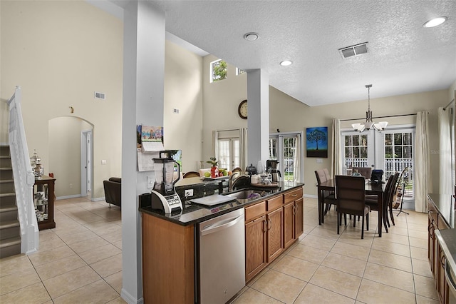 14213 Southern Red Maple Dr, Orlando, FL 32828 - kitchen with stainless steel dishwasher, brown cabinets, a textured ceiling, a chandelier, and light tile patterned floors