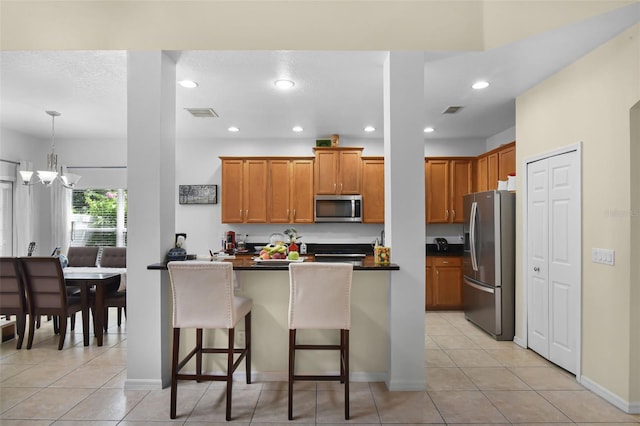 14213 Southern Red Maple Dr, Orlando, FL 32828 - kitchen featuring appliances with stainless steel finishes, dark countertops, a breakfast bar area, a chandelier, and recessed lighting