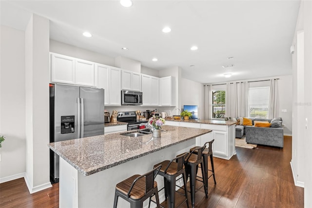 11686 Water Run Aly, Windermere, FL 34786 - kitchen featuring stainless steel appliances, a peninsula, dark wood finished floors, a kitchen bar, and recessed lighting