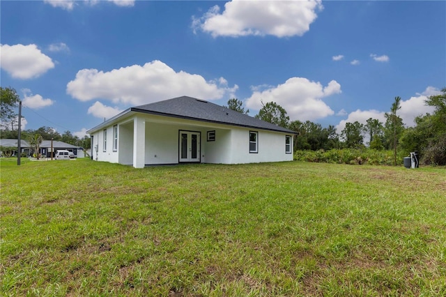 4447 Heyward St, North Port, FL 34291 - back of house featuring french doors, stucco siding, and a lawn