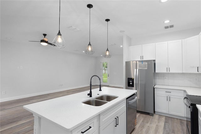 4447 Heyward St, North Port, FL 34291 - kitchen featuring stainless steel appliances, light wood finished floors, white cabinetry, hanging light fixtures, and recessed lighting