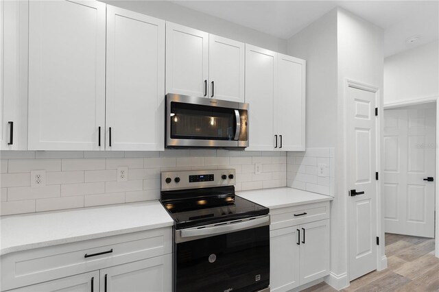 4447 Heyward St, North Port, FL 34291 - kitchen featuring stainless steel appliances, light wood-style floors, white cabinetry, and backsplash