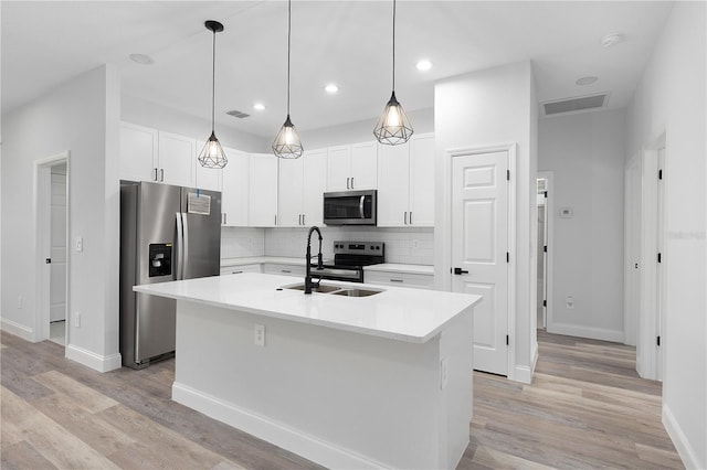 4447 Heyward St, North Port, FL 34291 - kitchen with appliances with stainless steel finishes, light countertops, decorative backsplash, a kitchen island with sink, and white cabinets