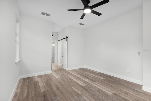 4447 Heyward St, North Port, FL 34291 - unfurnished room with wood finished floors, ceiling fan, and a barn door