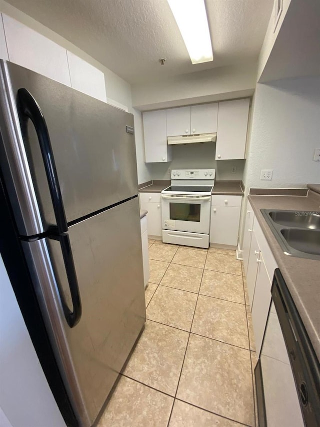 kitchen featuring white appliances, under cabinet range hood, a textured ceiling, white cabinets, and light tile patterned flooring