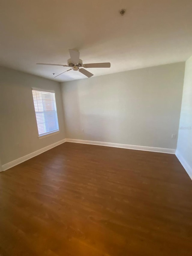 unfurnished room with dark wood-style floors and baseboards