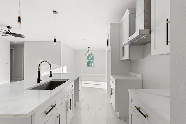 2446 Greenway, Sanford, FL 32771 - kitchen featuring wall chimney exhaust hood, light marble finish flooring, light stone counters, ceiling fan, and hanging light fixtures