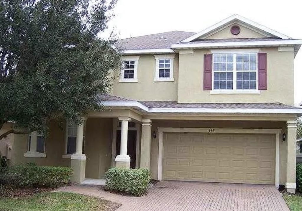 544 Legacy Park Dr, Casselberry, FL 32707 - view of front facade featuring an attached garage, stucco siding, and decorative driveway