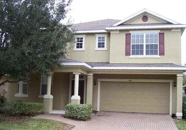 544 Legacy Park Dr, Casselberry, FL 32707 - view of front facade featuring an attached garage, stucco siding, and decorative driveway