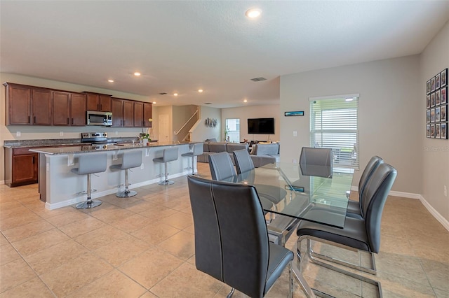 565 Ogelthorpe Dr, Davenport, FL 33897 - dining room featuring recessed lighting, light tile patterned floors, and stairs
