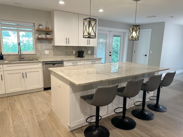 213 W Tilden St, Winter Garden, FL 34787 - kitchen with dishwasher, light wood-style floors, a center island, light stone counters, and recessed lighting