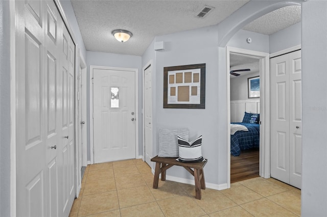 2980 Cool Breeze Cir, Saint Cloud, FL 34769 - foyer with arched walkways, a textured ceiling, and light tile patterned floors