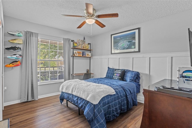 2980 Cool Breeze Cir, Saint Cloud, FL 34769 - bedroom featuring a textured ceiling, wood finished floors, wainscoting, and ceiling fan