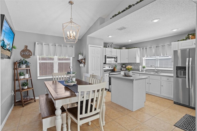 2980 Cool Breeze Cir, Saint Cloud, FL 34769 - kitchen with stainless steel appliances, a textured ceiling, a center island, and white cabinetry